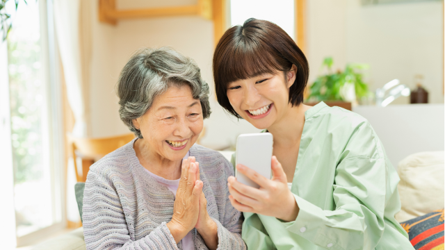 インターネットにつながっていることで喜ぶ高齢の女性と家族